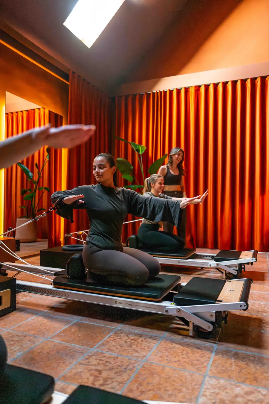 Trainerin und Teilnehmerinnen bei einer Übung auf dem Reformer